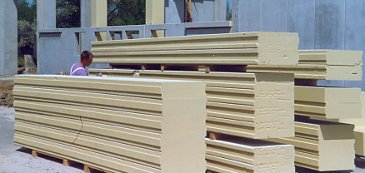 Ein Maler beschichtet Bauteile auf einer Baustelle.